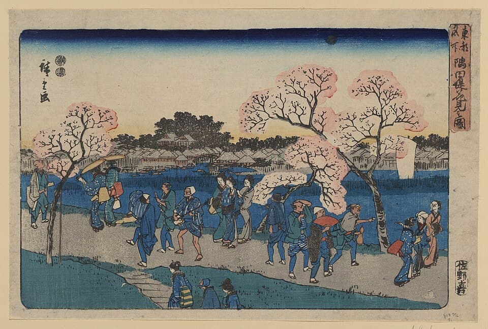 江戸時代の浮世絵。満開の桜の並木の下、隅田川の土手を大勢の人が行き交っている