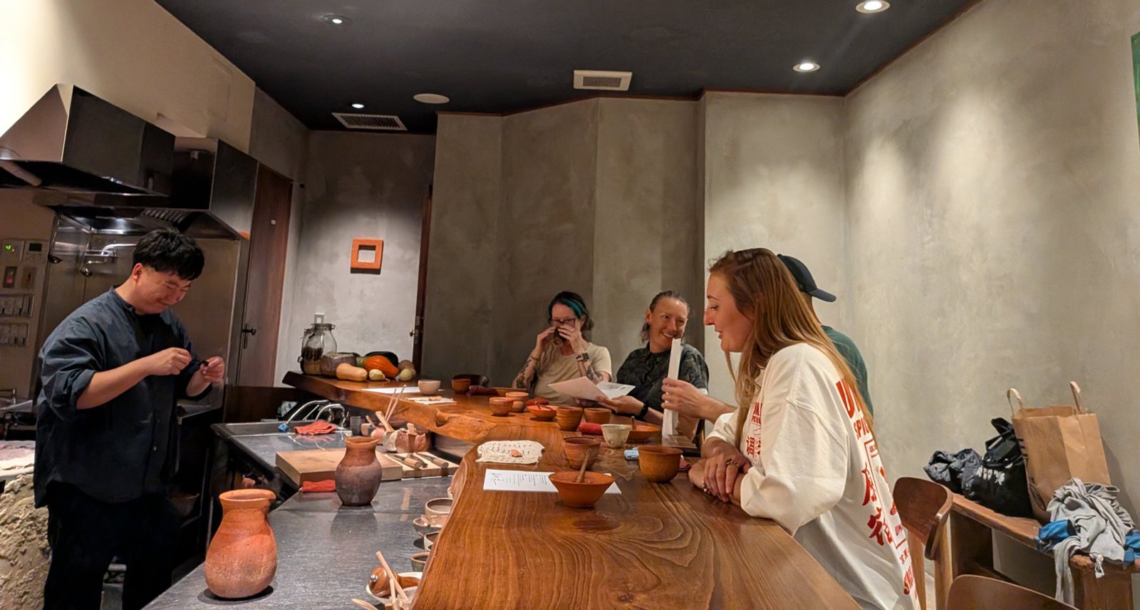 The four friends at the counter, reading their menu cards.