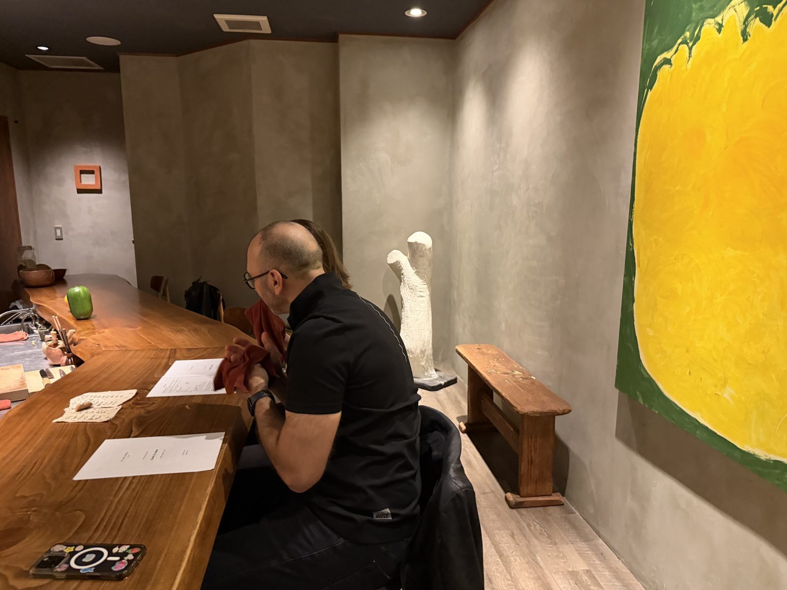 At the counter, the menu card in hand.