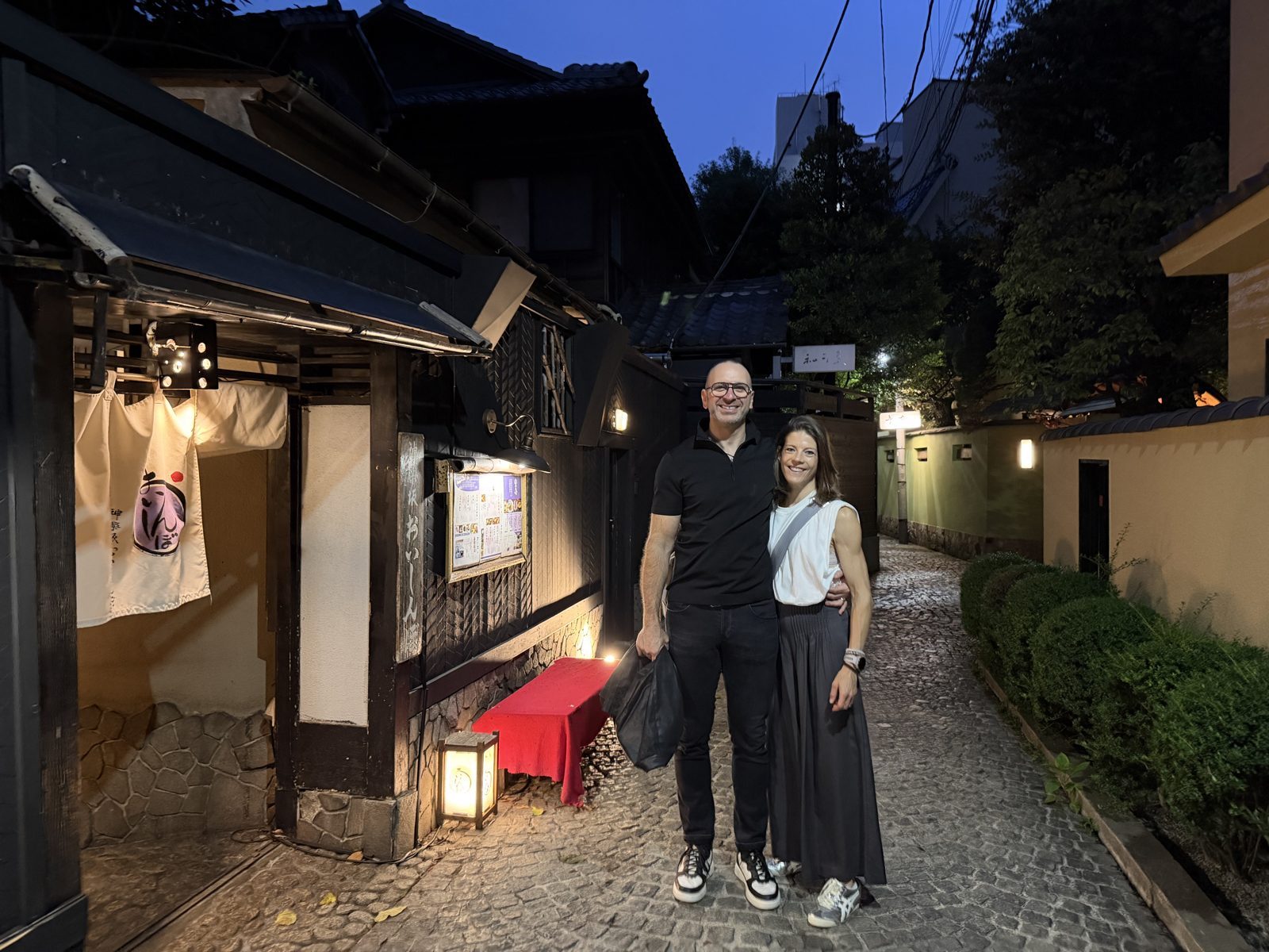 Two guests in a lantern-lit alley.